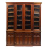 Late Victorian walnut library breakfront bookcase fitted with four glazed doors enclosing adjustable