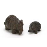 Two Japanese patinated bronze models of an elephant and hedgehog, each with impressed character