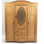 Large Victorian pine wardrobe with central oval mirror above three bow fronted drawers, flanked on