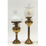 Two brass oil lamps with reeded columns and glass shades, both converted for electric use, the