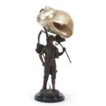 Early 20th century patinated spelter table lamp with shell shade, modelled as a young boy holding