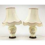 Pair of porcelain table lamps and shades, each decorated with peacocks amongst trees, overall 52cm