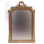 Wall mirror with applied scroll and beaded decoration with central crest of laurel wreaths to top,
