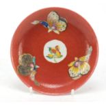 Chinese porcelain red ground saucer hand painted in the famille rose palette with butterflies, 12.