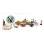 Metalware including brass chamber sticks, silver plated toast racks and a cylindrical enamelled