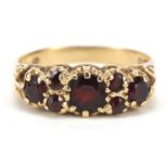 9ct gold garnet seven stone ring, size O, 2.4g : For Further Condition Reports, Please Visit Our