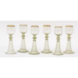 Set of six 19th century German green glass wine glasses with gilt borders, each 20cm high : For