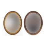 Two ornate gilt framed oval bevel edged wall mirrors, each approximately 68cm x 54cm : For Further