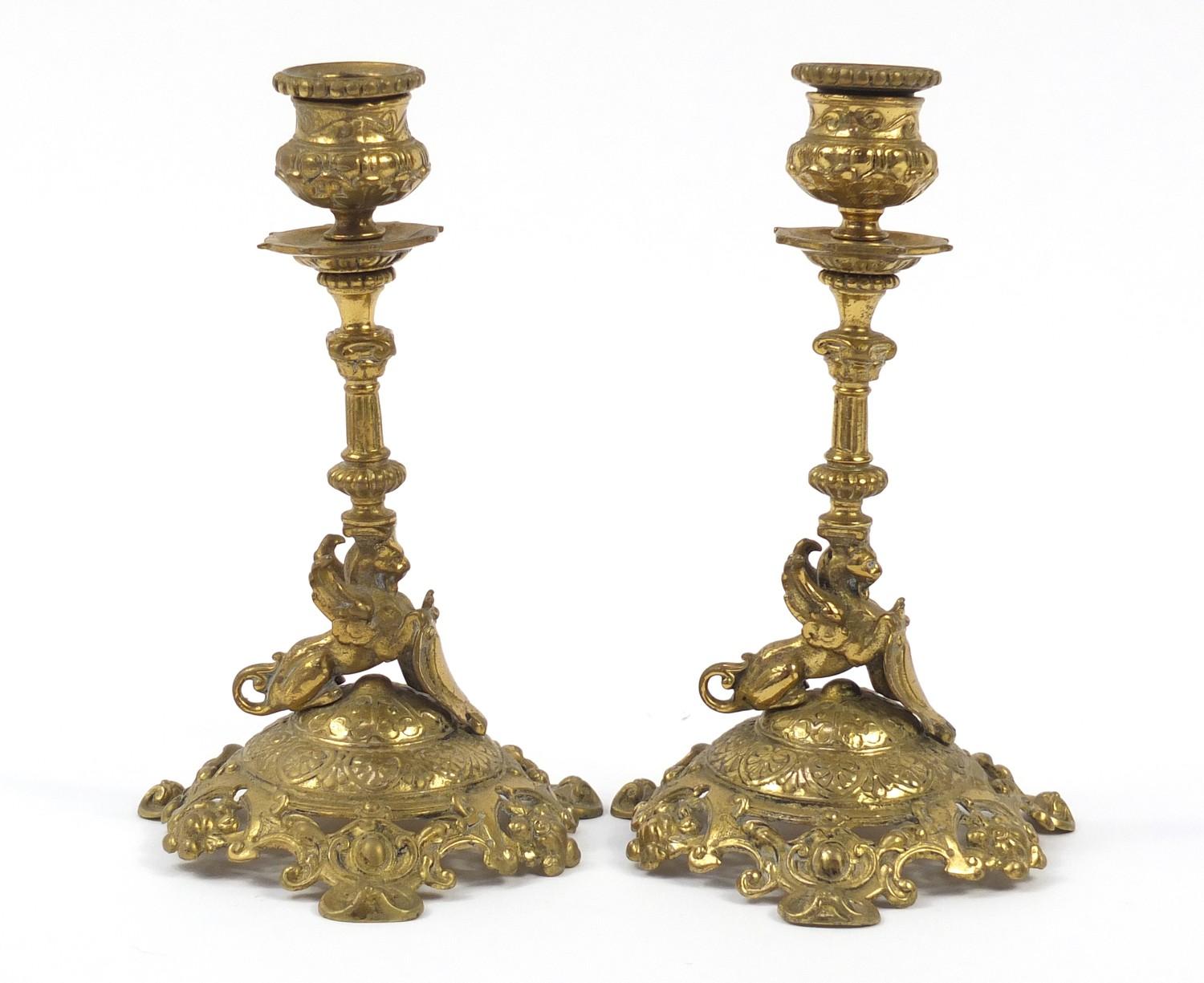 Pair of 19th century classical brass griffin design candlesticks, each 18.5cm high : For Further