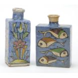 Two Turkish Iznik pottery flat sided flasks hand painted with fish and flowers, the largest 17.5cm