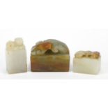 Three Chinese jade seals including a celadon and russet example, carved with a water dragon and a