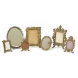 Six brass Art Nouveau and Victorian style easel photo frames and a silver plated example, the