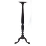 Mahogany torchere with circular top, reeded column and tripod base, 138cm high, the top 30cm in