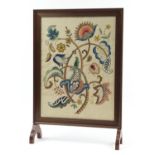 Victorian mahogany fire screen housing an Arts & Crafts type embroidered panel of flowers, 79cm high