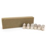 Six American sterling silver pepper pots with planished decoration housed in a cardboard case,