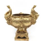 Large gilt bronze centrepiece in the form of a classical ern with two figures on paw feet, 66cm H