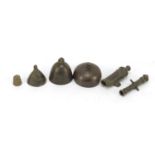 Four archaic miniature bronze bells and two miniature bronze cannons, the largest 5.8cm long : For