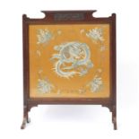 Chinese silk panel embroidered with a dragon and flowers, housed in a carved mahogany screen,