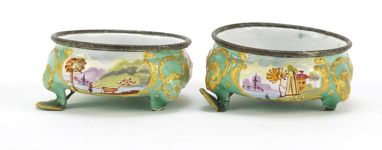 Pair of 19th century French enamel salts, hand painted with panels of farm and landscape scenes, 7cm
