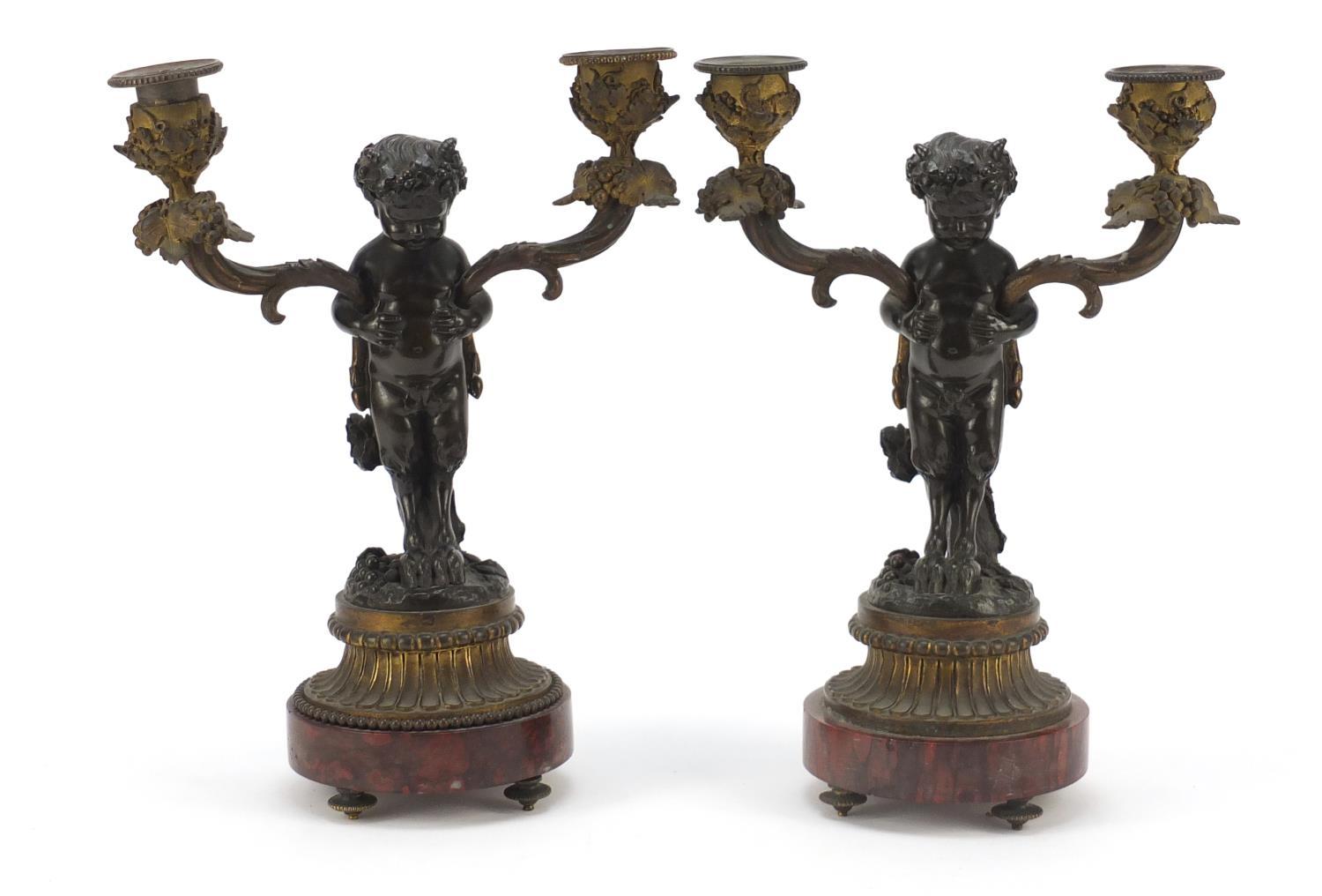 After Claude Michel Clodion, pair of 19th century patinated bronze figural two branch candlesticks