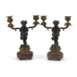 After Claude Michel Clodion, pair of 19th century patinated bronze figural two branch candlesticks