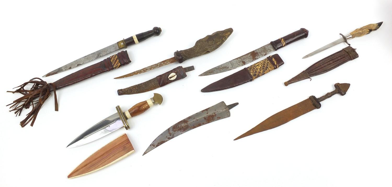 Seven daggers including a taxidermy interest example with lizard head handle, the largest 35cm in