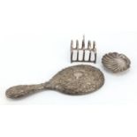 Silver items comprising four slice toast rack, shell shaped dish and hand mirror, various hallmarks,