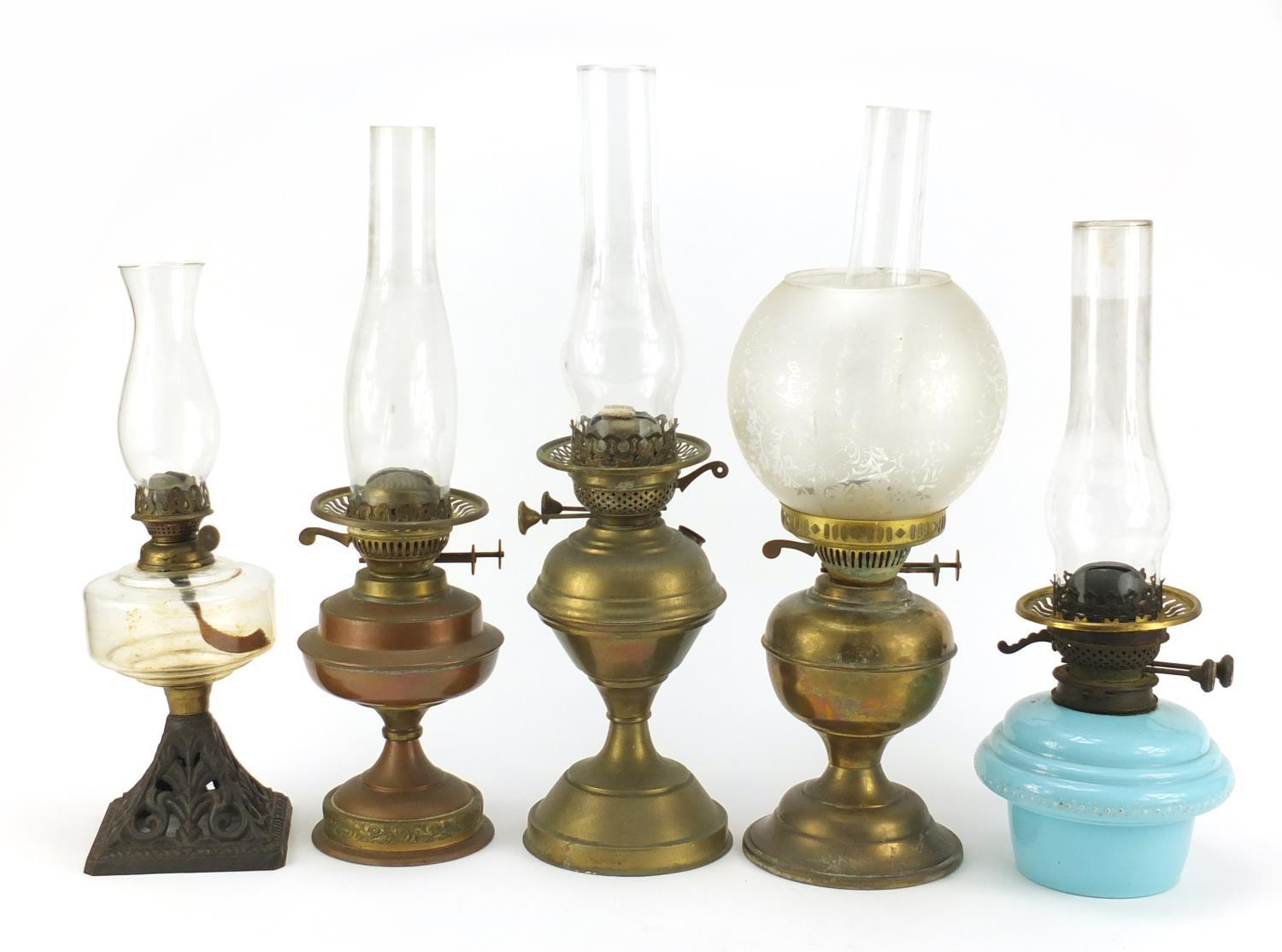 Five brass and glass oil lamps, the largest 51cm high : For Further Condition Reports Please Visit