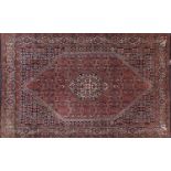 Iranian wool rug with all over floral design onto a predominantly blue and red ground, 146cm x