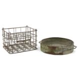 Vintage wrought iron milk bottle stand and a grain sifter, the largest 47cm in diameter excluding