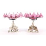 Pair of silver plated and ruby glass tazzas cast with mythical winged creatures, numbered 2832, 25cm