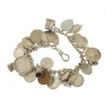 Silver charm bracelet with a selection of mostly silver charms and coins, 87.0g : For Further