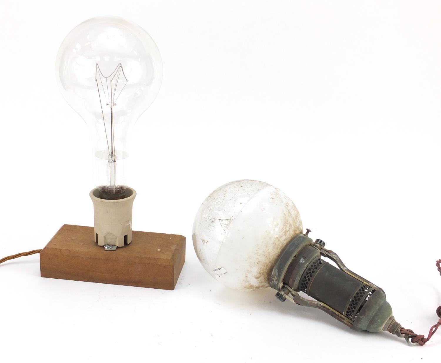 Two large Industrial style bulbs, one on a gimbal support, the other mounted on a wooden block,