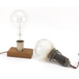 Two large Industrial style bulbs, one on a gimbal support, the other mounted on a wooden block,
