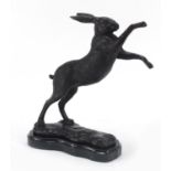 Patinated bronze boxing hare raised on a shaped black marble base, 30cm high : For Further Condition