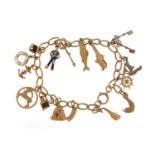 9ct gold charm bracelet with a selection of mostly gold charms including enamelled sailor, enamelled