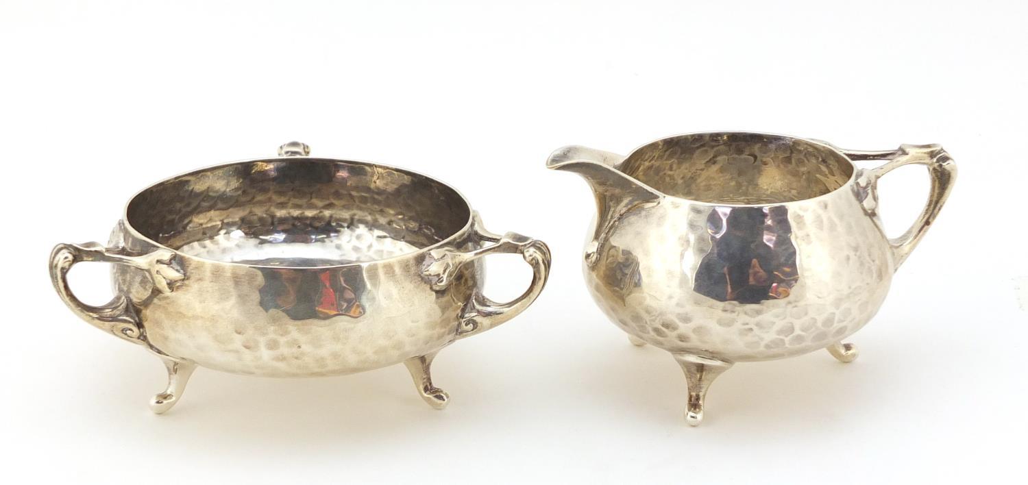 Northern Goldsmith Company, Arts & Crafts planished silver milk jug and sugar bowl, London 1901, the