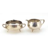 Northern Goldsmith Company, Arts & Crafts planished silver milk jug and sugar bowl, London 1901, the
