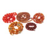 Five amber coloured bead necklaces, the largest 140cm in length, 327.6g : For Further Condition