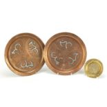 Three Egyptian Cairo ware plates including a copper pair, each with silver inlay, 23.5cm in diameter