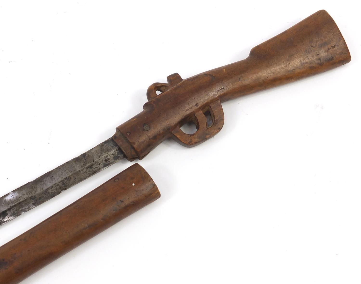 African carved wood sword stick in the form of a rifle, 86cm in length : For Further Condition