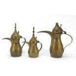 Graduated set of three Omani brass coffee pots, engraved marks to the bases, largest 18cm high : For