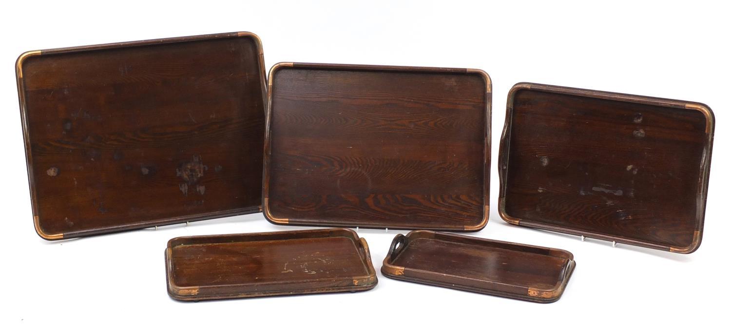 Graduated set of five oak trays with copper mounts, the largest 62cm x 44cm : For Further