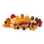 Group of amber coloured beads, the largest 6cm in length, 306.0g : For Further Condition Reports