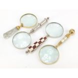 Four magnifying glasses including one with chequered design handle, the largest 26cm in length : For