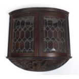 19th century bow fronted wooden wall hanging cabinet with leaded glazed doors, with carved dragon