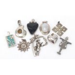 Nine silver pendants including a fossilised ammonite, love heart and crucifix, the largest 6.5cm