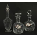 Three cut glass decanters including two with porcelain decanter labels, the largest 30.5cm high :