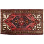 Rectangular Afgan rug decorated with stylised flowers onto a predominantly red and blue ground,