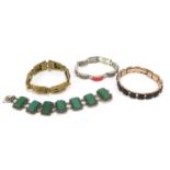 Four bracelets including a silver example set with green hardstone panels and a brass Art Nouveau